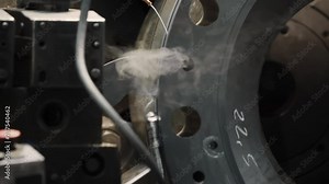 Metal cutting machinery is operating at the industrial manufacturing plant. Machinery is slowly cutting metal off the turbine detail. Metal cutting machinery scraping the steel off a product. Steam