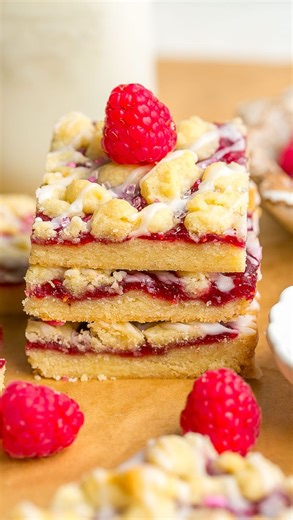 Kathryn Donangelo on Instagram: "Raspberry Shortbread Cookie Bars❤️ Made with a buttery shortbread crust and filled with sweet raspberry jam, topped with more shortbread and drizzled with a light glaze. Made with only 6 ingredients and easier to make than cookies! ️⭐️️️Comment ”RECIPE” and I’ll instantly send you the full recipe! 📌https://kathrynskitchenblog.com/raspberry-shortbread-cookie-bars/ #shortbread #cookiebars #sweettreat #valentinesday #thebakefeed"
