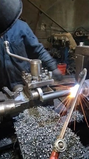 A bent shaft is heat-corrected on a lathe.