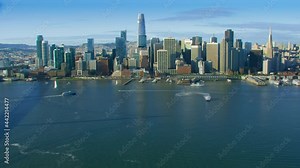 Aerial view of the San Francisco Ferry building with its clock tower. Famous piers and the Financial District. Shot in 8K. California, United States.