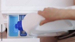 Woman pouring gel detergent in washing machine. Putting Laundry Detergent Pod into the Washing Machine. Washing clothing in domestic washing machine