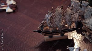 Model of a wooden ship on the old wooden beam. Camera panning from wooden turtle to model of ship.