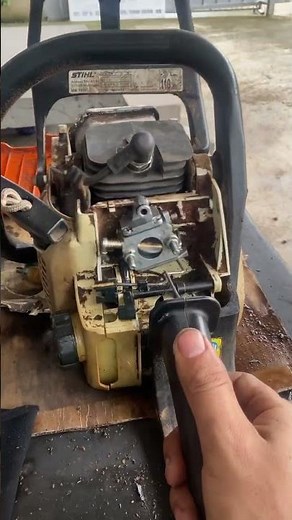 Cleaning the carburetor for a chainsaw.