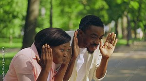 Cheerful parents playing peek-a-boo with infant in stroller, baby development