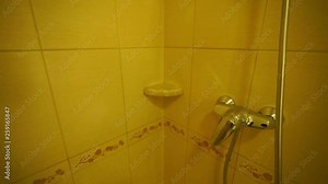 Hotel room bathroom with shower cabin. Taking a shower first person view. Some person opens the glass door and turns on the water.
