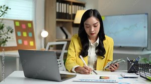 Asian businesswoman, young woman in office holding stack of money, counting banknotes, keeping track of financial details, expenses, financial business accounts in modern office calculation concept.