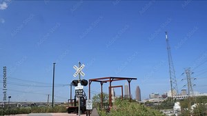Cleveland, Ohio Towpath trail head for biking and running near downtown industry along the Cuyahoga River. Clear day with some clouds and blue skies and a railroad crossing feature.