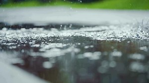 Female sports woman jogging outdoors, stepping into puddle. Single runner running in rain, making splash. Slow motion