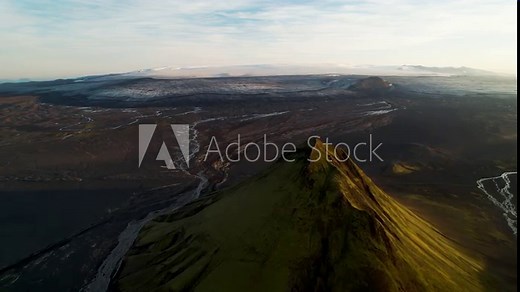 Aerial view of Maelifell mountain at sunset, a tall volcano that stands out in a desert of black sands, Iceland.