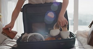 clip-1024547687-travel-woman-packing-suitcase-getting-ready-road