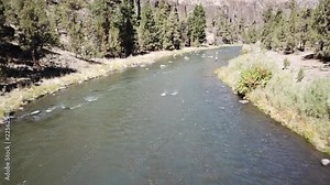 Flight over flyfisherman in the high desert of central Oregon over premier flyfishing trout stream in the crooked river canyon