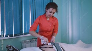 cosmetologist puts disinfected electrodes onto woman belly to remove striae distensae with electrical myostimulation procedure in clinic