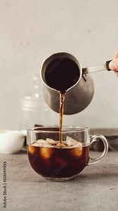 Cold Brew coffee making process. Hand pouring coffee and milk into a glass mug with ice. Stop motion animation video