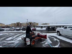 SCAG stand on mower with BOSS ATV/UTV V-Plow clearing handicap parking spaces. Light 1/2” snow.