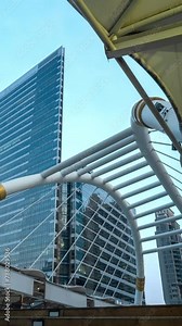 Vertical time lapse video at a crosswalk bridge in central business district in Bangkok, Thailand.