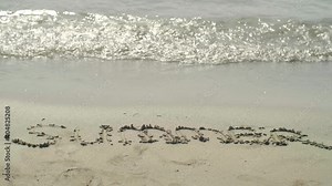 Summer post written in the sand on the beach. Slow motion video.