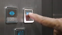 Hand pressing elevator button