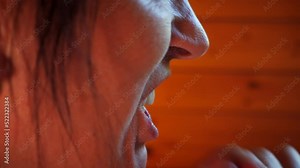 Mouth of elderly woman with false teeth. Insertion of dentures. Removable jaw