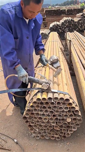 Stahlrohre binden: Wie ein Handwerker mit Druckluft und Stahlband Ordnung schafft