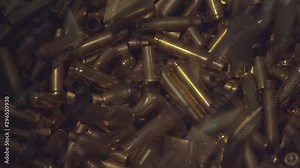 Spend bullet casings falling on floor filled with shell casings in slowmotion