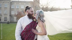 A beautiful swedish bride and groom looking at each other in front of the castle, a bridal veil is fluttering