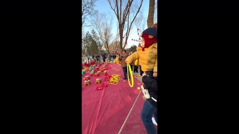 Child throws hoop perfectly onto man's shoulders in Beijing