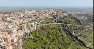 Aerial view of the historic center of Catanzaro and the famous access bridge to the city. It is the capital of Calabria, southern Italy. In the background is the Ionian Sea.
