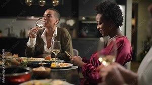 Woman texting during dinner party with friends at home