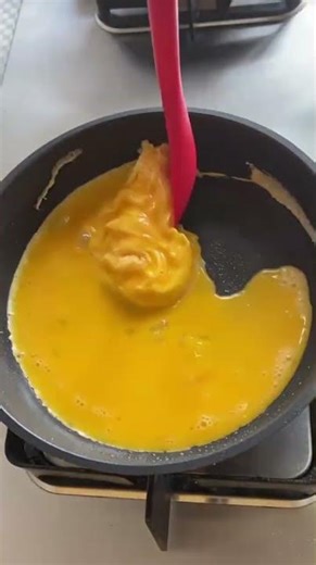 Cooking a fluffy omelet on a nonstick pan, forming a smooth, golden layer with perfect texture.