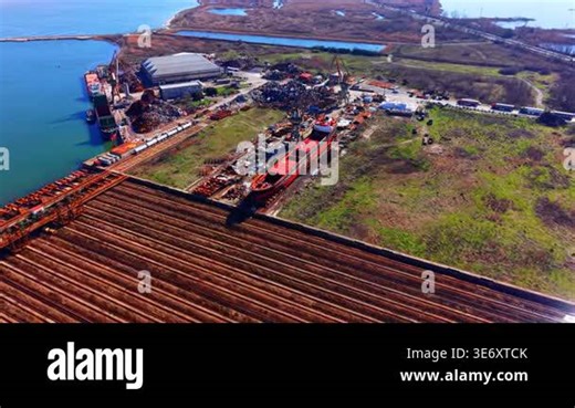 Coastal industrial zone featuring cargo ships, scrap piles, rail tracks, and warehouse buildings. Wide aerial panorama of industrial port and shipyard area Stock Video Footage - Alamy