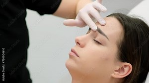 The cosmetologist makes markings on the patient's face, drawing correction lines before the facial contouring procedure or plastic surgery. preparation time for cosmetic treatment.