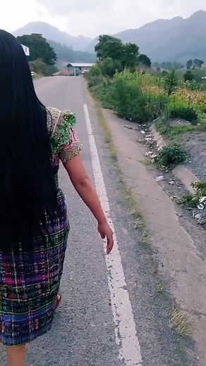 Woman in Traditional Dress Walking Through Rural Landscape
