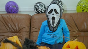 Child in Scream halloween mask makes spooky hand gestures - Free Stock Video