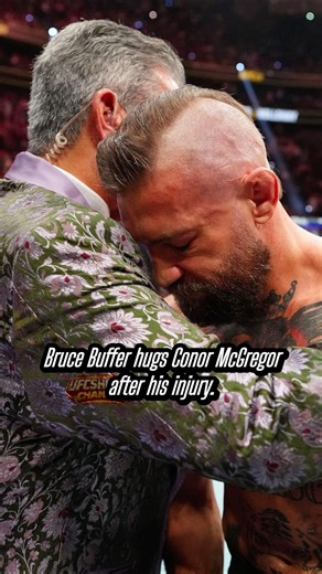 Bruce Buffer hugs Conor McGregor after the injury.