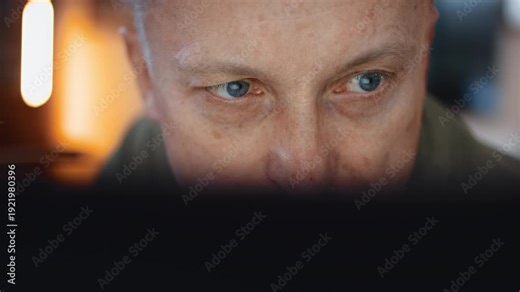 Close-up man sitting in front of a laptop or a computer and looking at the display screen to fill out taxes