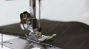Slow motion of needle with thread of sewing machine sew leather fabric for textiles and clothing. Close up of work process of sewing machine in atelier. Textile industry, manufacturing and fashion