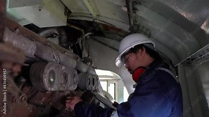 Industrial engineers,technicians,and supervisors inspecting and repairing machinery in the engine room,servicing and maintaining large locomotive engines,ensuring optimal performance and reliability i