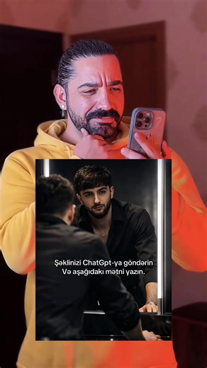 Hypic ilə öz selfini peşəkar güzgü qarşısında sinematik portretə çevir (Güzgü qarşısında cinematic portrait AI filter tutorial) ✨📸🎬 realistic cinematic mirror portrait, vertical. Confident man in a black tailored outfit, slightly unbuttoned black shirt with thin chain, standing before a modern LED-lit mirror. Shot from behind with clear reflection, leaning forward in a powerful, introspective pose. Soft cinematic LED lighting, deep shadows, high contrast, minimal dark background. Photorealisti