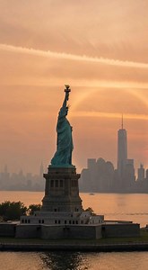 It looks symbolic… but it’s pure physics. ☀️👑 As the Sun aligned perfectly with the torch of the Statue of Liberty, a rare 22° solar halo formed around it — creating this stunning crown of light over New York Harbor. That glowing ring isn’t editing magic. It happens when sunlight passes through millions of hexagonal ice crystals high in the atmosphere, bending light at exactly 22 degrees. Timing. Atmosphere. Geometry. Location: New York City 🇺🇸 Would you call this luck… or science? | Astronom