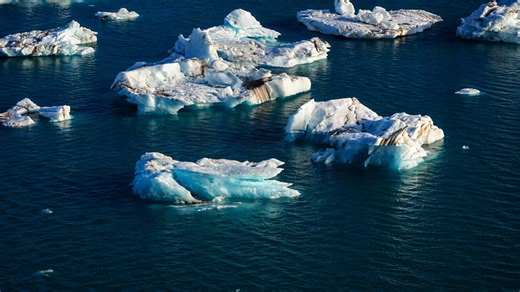 Frozen giants breaking apart on a serene blue surface