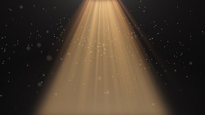 The spotlight illuminates the stage background. Spotlight with flying particles. Gold color rays. Empty scene with light for product.  4k video