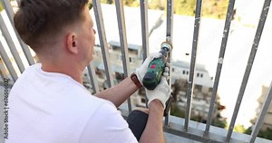 Removing rust and paint from balcony railings using angle grinder