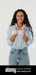 Cheerful young woman applauding and clapping hands. Happy female model showing appreciation, gratitude or hope isolated on white background.