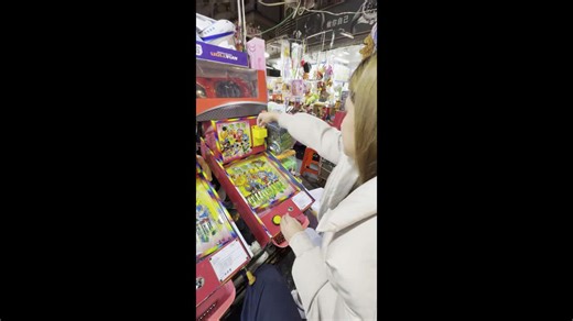 Tourist engrossed by mini pinball machine at arcade in Taiwan