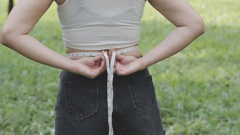 clip-4007517693-close-shot-woman-measuring-waistline-body-measurement