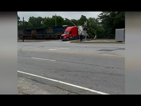 Wild video of a train crashing into a stalled tractor trailer with driver standing just feet away