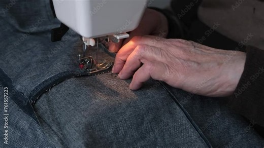 A seamstress sews on a sewing machine. The sewing machine needle is in motion. The process of sewing fabric.