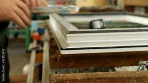 Production and manufacturing of pvc windows, male worker produces pvc window assembly collects sash windows, pvc profile, window assembly