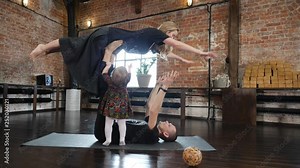 Acro yoga studio family father practice a pose with mother and baby daughter