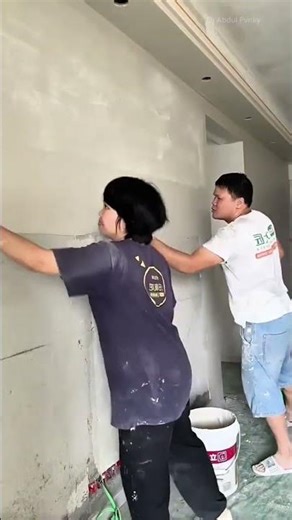 plastering the wall with a scraper to create a smooth surface for home renovation and construction
